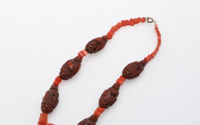 A 19TH CENTURY CHINESE (QING DYNASTY) HADAIO CARVED NUT BEAD AND CORAL NECKLACE.