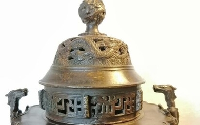 A Chinese 20th century tripod patinated bronze censer, feet shaped as elephants heads, pierced lid, finial with entwined dragons. Weight 1350 g. H. 20 cm