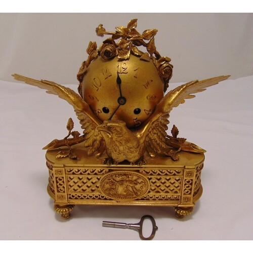 A French gilt metal mantle clock of globular form supported ...