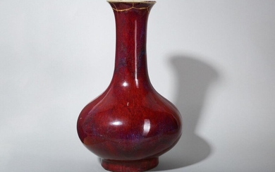 A LARGE CHINESE FLAMBÉ-GLAZED BOTTLE VASE. Qing Dynasty. With a compressed ovoid body set on a straight foot decorated with a dark red glaze with green and lavender streaks draining from the flared rim, 41cm H. 清 窯變釉撇口瓶