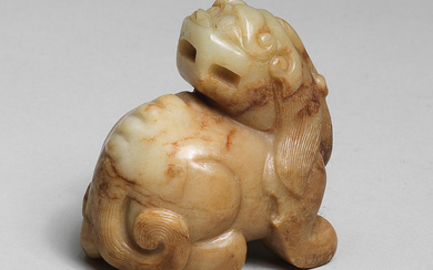A PALE GREEN AND RUSSET JADE CARVING OF A MYTHICAL...