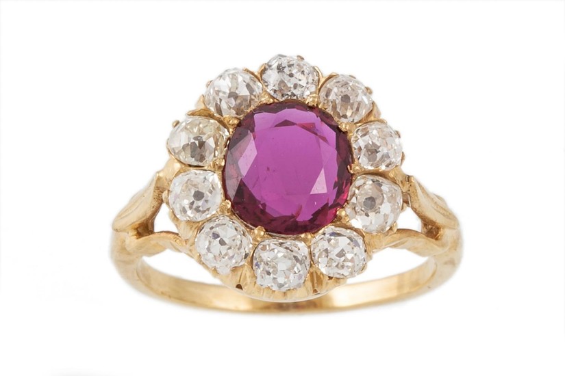 A RUBY AND DIAMOND CLUSTER RING, the oval ruby to an old cut...