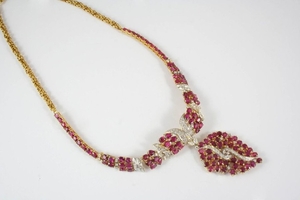 A RUBY AND DIAMOND NECKLACE the scrolling foliate …
