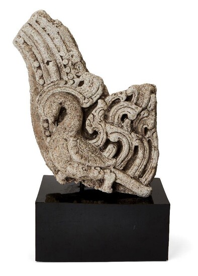 A carved stone fragment with bird, possibly Sri Lanka or Java, 10th century or later, formerly the side of an arched element, deeply carved, the bird with curved neck, mounted, fragment 32cm. high x 22cm. diam. x 13cm. deep Provenance: Formerly in...