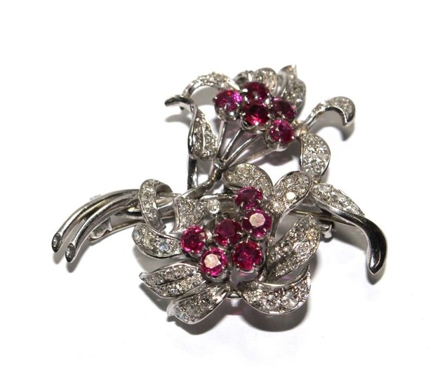 A diamond and ruby two headed flower brooch in fitted Carrin...