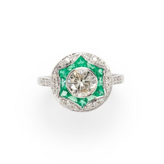 A diamond, emerald and eighteen karat white gold ring