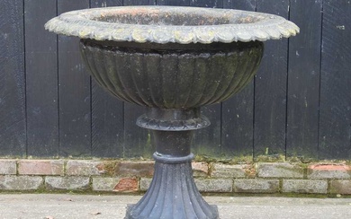 A large black painted cast iron garden planter, of fluted...