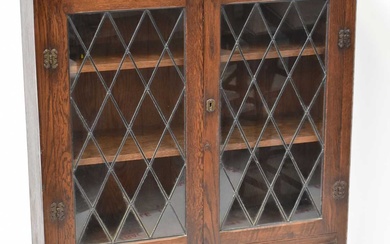 A mid-20th century oak cabinet with leaded glazed doors, above...