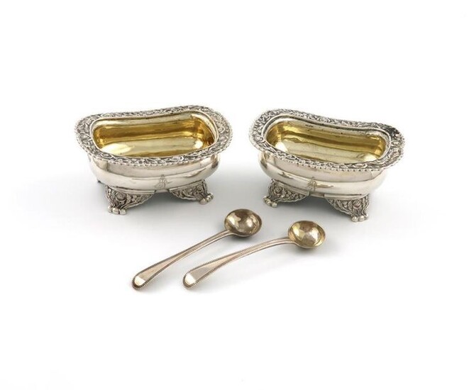 A pair of George IV silver salt cellars, by Charles and John Fry, London 1823, rounded rectangular form, foliate scroll borders, gilded bowls, on four foliate bracket feet, engraved with a crest, with two salt spoons, length 10.2cm, approx. weight...