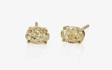 A pair of earrings with light fancy yellow diamonds