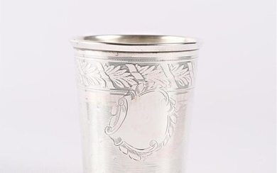 A silver truncated-cone shaped timbale, it has on the belly a moving blind cartouche inscribed on a guilloche pattern background dotted with stars, the rim decorated with a wide frieze of alternating foliage and ribbons.