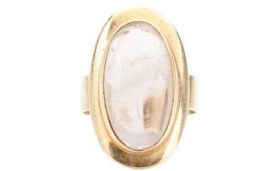 A smoky quartz cabochon dress ring, featuring an elongated oval smokey quartz of 2.3 x 1.1 cm, in a