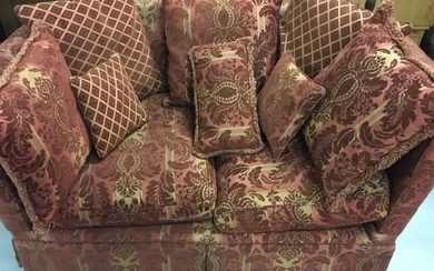 A two-seater knole sofa, upholstered in burgundy & cream...