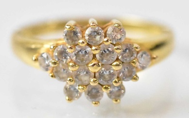 A yellow metal cluster ring set with sixteen small white...