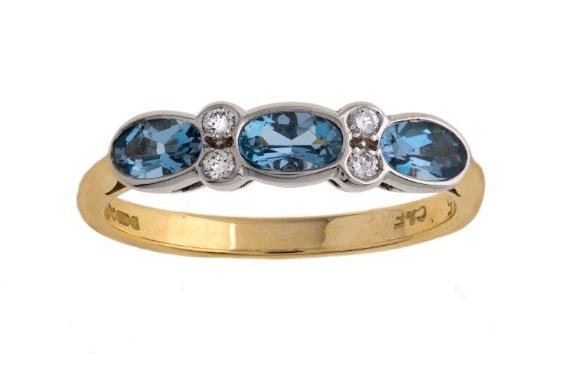 An 18ct gold, aquamarine and diamond ring, of half hoop design, set with three oval aquamarines, accented with brilliant-cut diamonds, ring size N, British hallmarks for 18-carat gold