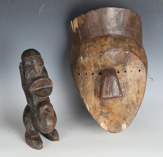 An African carved dense hardwood figure of stylized form, height 26cm, together with an African carv