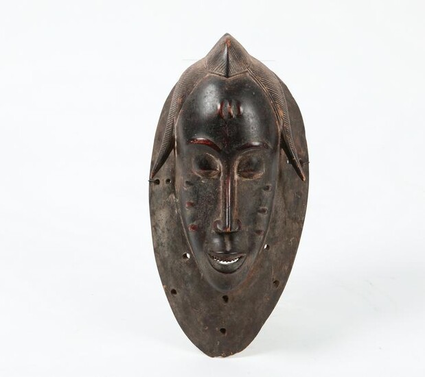 An African carved hardwood Guro mask, Ivory Coast