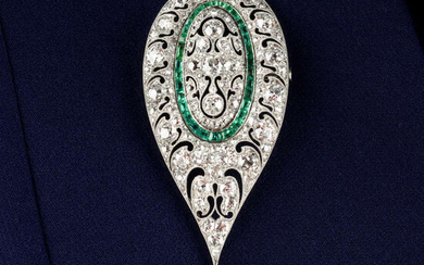 An Art Deco platinum, diamond, emerald and pierced brooch.