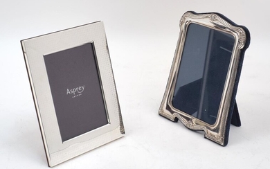 An Asprey silver mounted picture frame, the frame all-over inscribed Asprey, on mahogany easel support, in original box, 17.4cm x 13.7cm, together with a silver mounted picture frame, Sheffield, 1994, Carr's of Sheffield Ltd, with velvet lined...