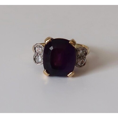 An amethyst dress ring flanked by a pair of circular diamond...