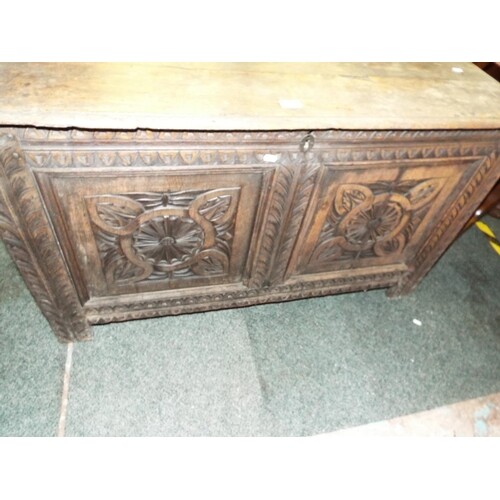 An early Victorian oak three planked top carved panelled cof...