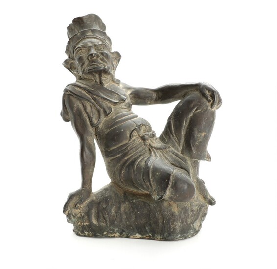 Asian bronze figure of man with headdress seated at rock. 19th-20th century. H. 19 cm.