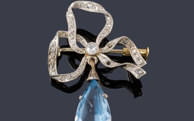 Broche en forma de lazada con diamantes talla rosa y antigua con remate de espinela azul sintética talla perilla. Circa 1910.