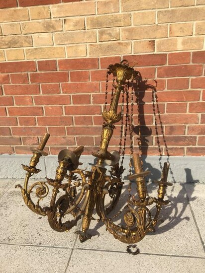 Chandelier in chased gilt bronze with six moving light arms with foliated scrolls ending with eagle beaks. The shaft is made of quiver. Empire style Tall: 80 cm Diam: 65 cm (one arm twisted, missing and accidents)