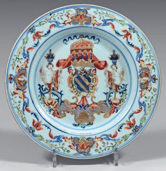 Chinese porcelain dish. Kangxi-Yongzheng, 18th century, circa 1720-25. Decorated with the enamels of the Rose Family, in the centre of which is a coat of arms surmounted by a crown and a canopy and framed by terms and a rocaille console in a medallion...