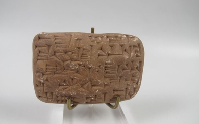 MESOPOTAMIE. Tablette inscrite en caractères cunéiformes. Terre cuite beige. L 7x4.5cm. Style babylonien