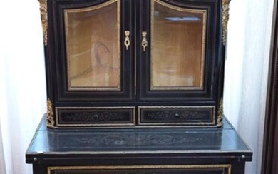Napoleon III's showcase desk, c. 1860. In ebony wood, with brass and gilt bronze inlays and applications. Upper part with double glazed door and two drawers at the front. Cabriolet legs and red leather mat. Measurements: 156x54x85