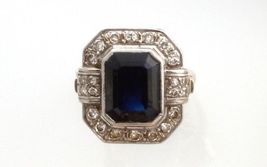 RING in 750 thousandths white gold and platinum holding an emerald-cut sapphire surrounded by diamonds. Art Deco period. TDD: 51. Gross weight : 6.54 gr. An Art Deco white gold and sapphire ring