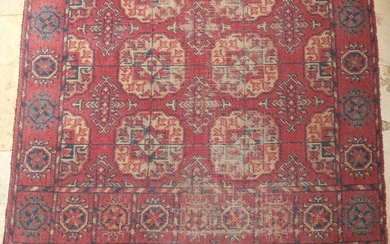 Tapis oriental à motif de pieds d'éléphants, fond rouge. Dimensions : 390 x 87 cm...