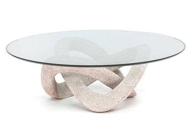 Tulczinsky: “Andromeda”. Coffee table with sculpted base of carved granitic material. Circular top of clear glass. Diam. 120 cm.