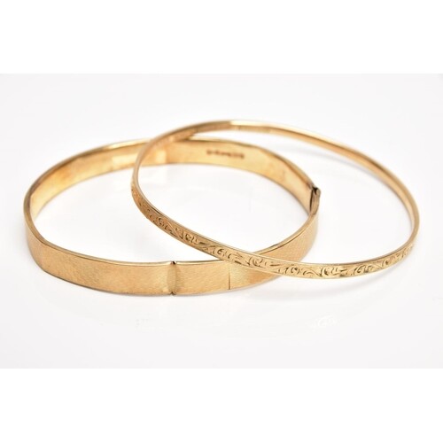 A 9CT GOLD BANGLE AND A YELLOW METAL BANGLE, the first an AF...