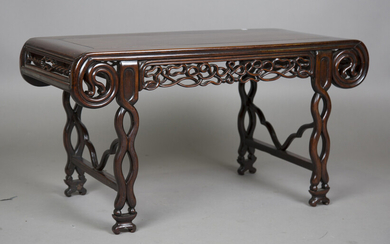 A Chinese hardwood low table, early 20th century, the rectangular panelled top with scroll ends abov