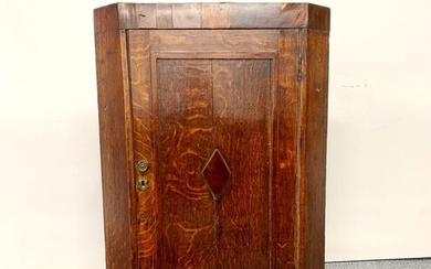 A Georgian inlaid oak wall mounted corner cabinet, W. 62cm.