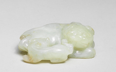 A PALE GREEN JADE CARVING OF A MYTHICAL BEAST AND...