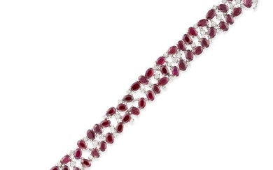 A RUBY AND DIAMOND BRACELET set throughout with oval cut rubies accented by round brilliant cut d...