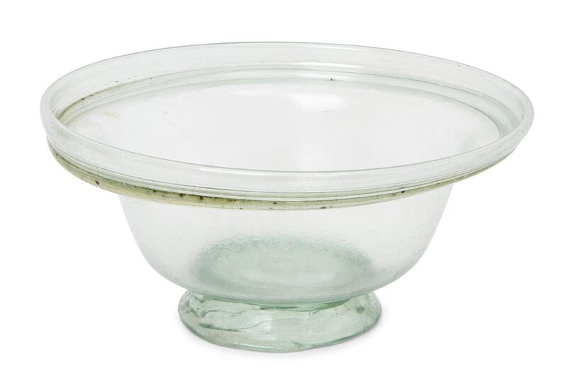 A Roman pale green glass bowl with collar rim and tooled ring base, circa 4th Century A.D., 13cm diam., 6.3cm high Provenance: Acquired by the current owner’s grandmother in the 1970s.