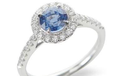 A SAPPHIRE AND DIAMOND CLUSTER RING IN 18CT WHITE GOLD, CENTRALLY SET WITH A ROUND CUT BLUE SAPPHIRE OF 1.20CTS, IN A SURROUND OF DI...