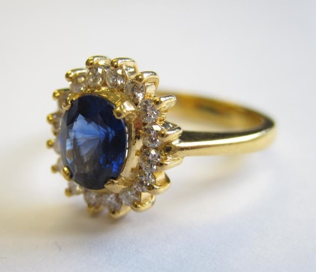 A Sapphire and Diamond Cluster Ring claw-set oval-cut sapphire,...