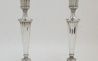 A pair of Edwardian silver candlesticks, Chester, 1913, Barker Brothers (Herbert Edward Barker & Frank Ernest Barker), in the Neo-Classical style with urn surmounts, on stepped oval bases, 31.5cm high (2)
