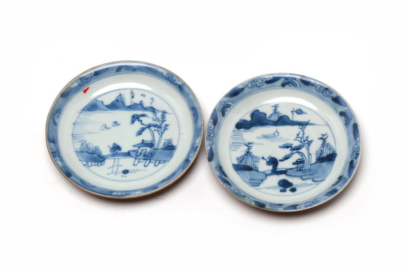 A pair of blue and white porcelain saucer, each painted to interior with landscape design and a brown color exterior