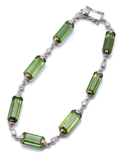 AN 18CT WHITE GOLD GREEN TOURMALINE AND DIAMOND BRACELET; composed of 7 long step cut green tourmaline set links between 8 round bri...