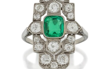 An Art Deco, platinum, emerald and diamond panel ring, the rectangular stepped bezel set in the centre with a single collet-set cushion-cut emerald weighing approximately 1.10 carats, within old-brilliant-cut diamond geometric design surround...