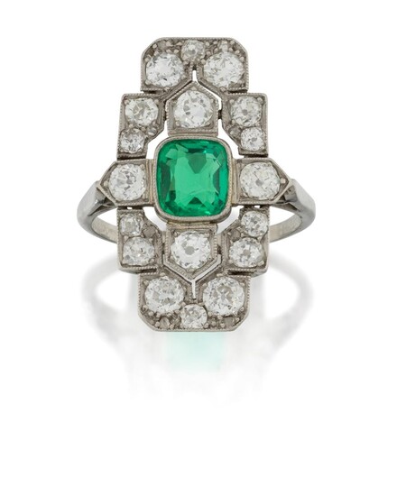 An Art Deco, platinum, emerald and diamond panel ring, the rectangular stepped bezel set in the centre with a single collet-set cushion-cut emerald weighing approximately 1.10 carats, within old-brilliant-cut diamond geometric design surround...