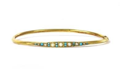 An Edwardian gold split pearl and turquoise oval bangle