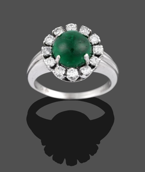 An Emerald and Diamond Cluster Ring, the cabochon emerald within...