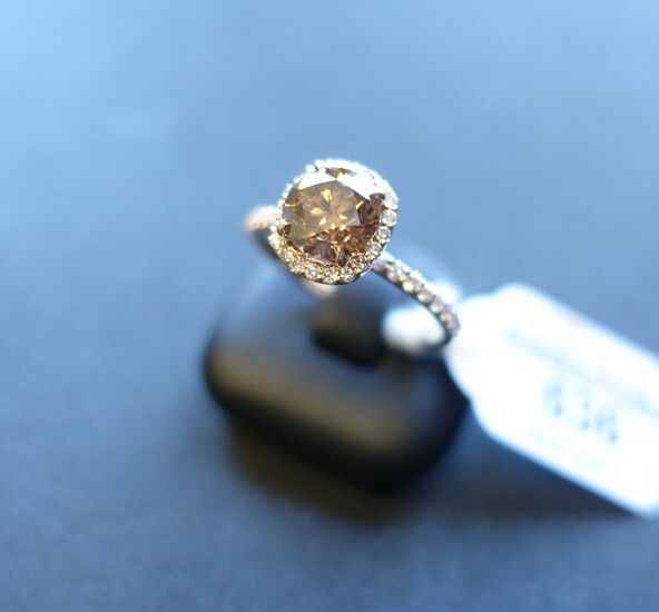 Bague en or rose 750 millièmes, ornée au centre d'un diamant rond de taille brillant...